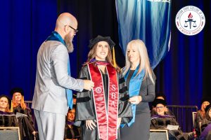 Student hooded at commencement ceremony.