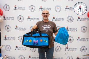 James Gilliam holding a bag packed for youth.